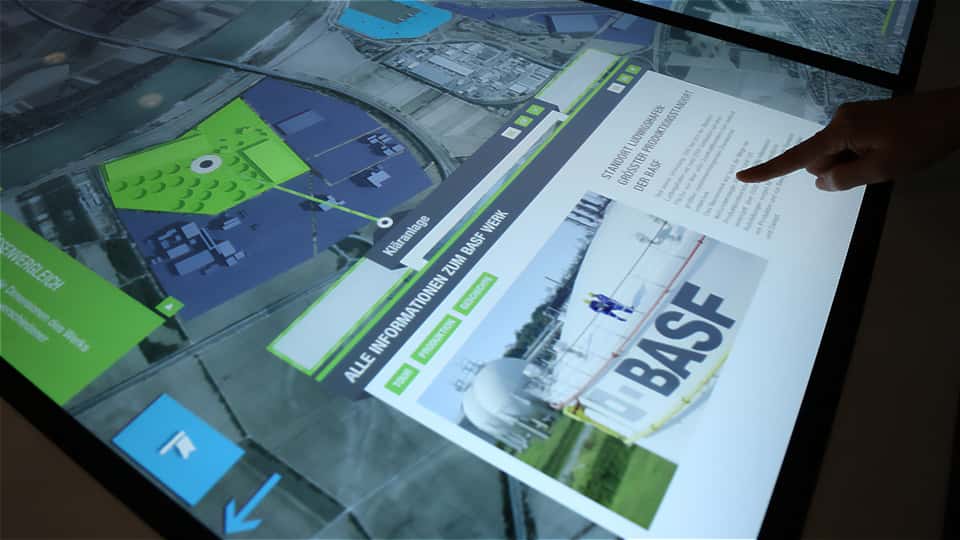 Detail view of an information panel on the multitouch table showing site data, images, and contextual text content.