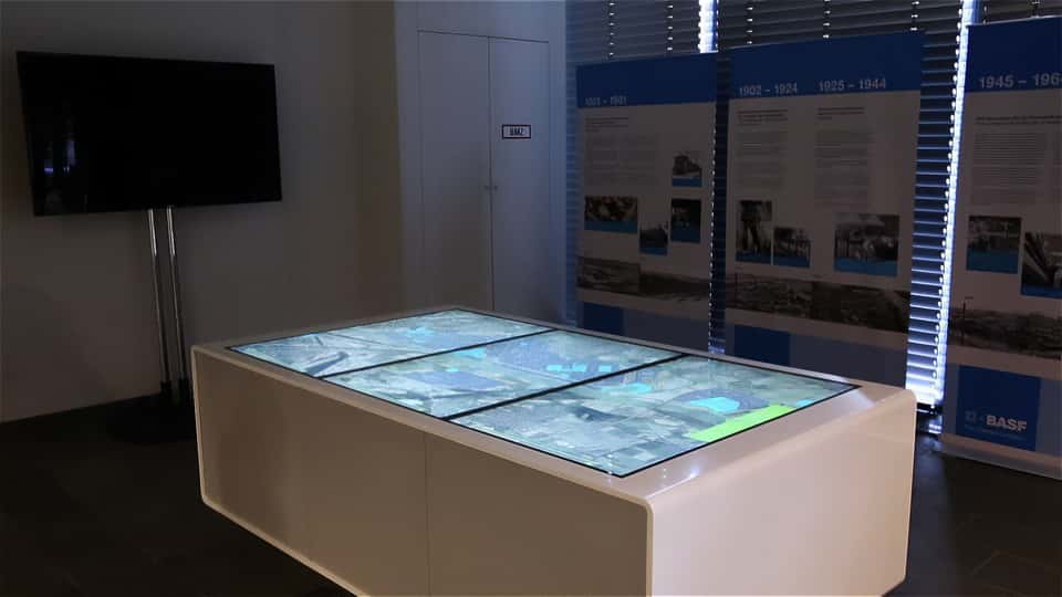Wide view of the BASF media table installation within the visitor center exhibition space.